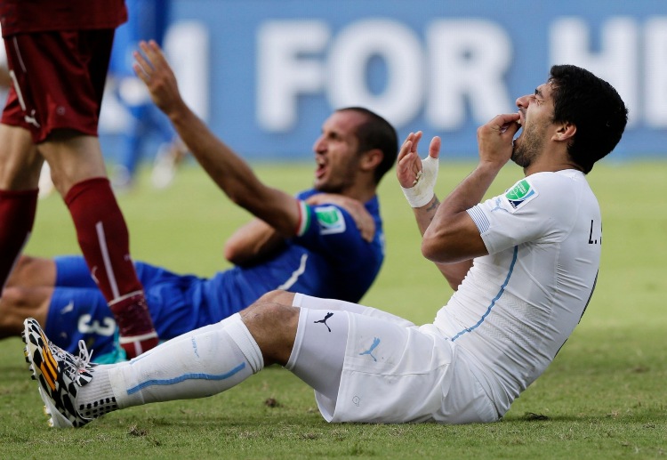 Luis Suarez holds his teeth after the biting incident against Giorgio Chiellini during the World Cup